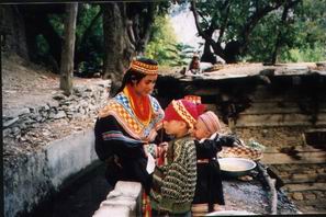 A Kalashi girl with children in Bomburet- Chitral, isolated valley among the Hindu-Kash mountains where Alexander the Great marched through here in 326BC